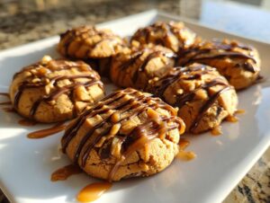 Close-up of warm apple pie cookies topped with chopped nuts, chocolate drizzle, and caramel sauce.