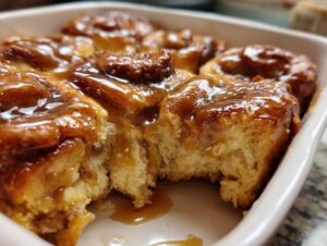 Close-up of a gooey cinnamon roll casserole with a caramel glaze.