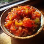 Close-up of a bowl filled with vibrant, chunky homemade salsa, featuring tomatoes, onions, and peppers.