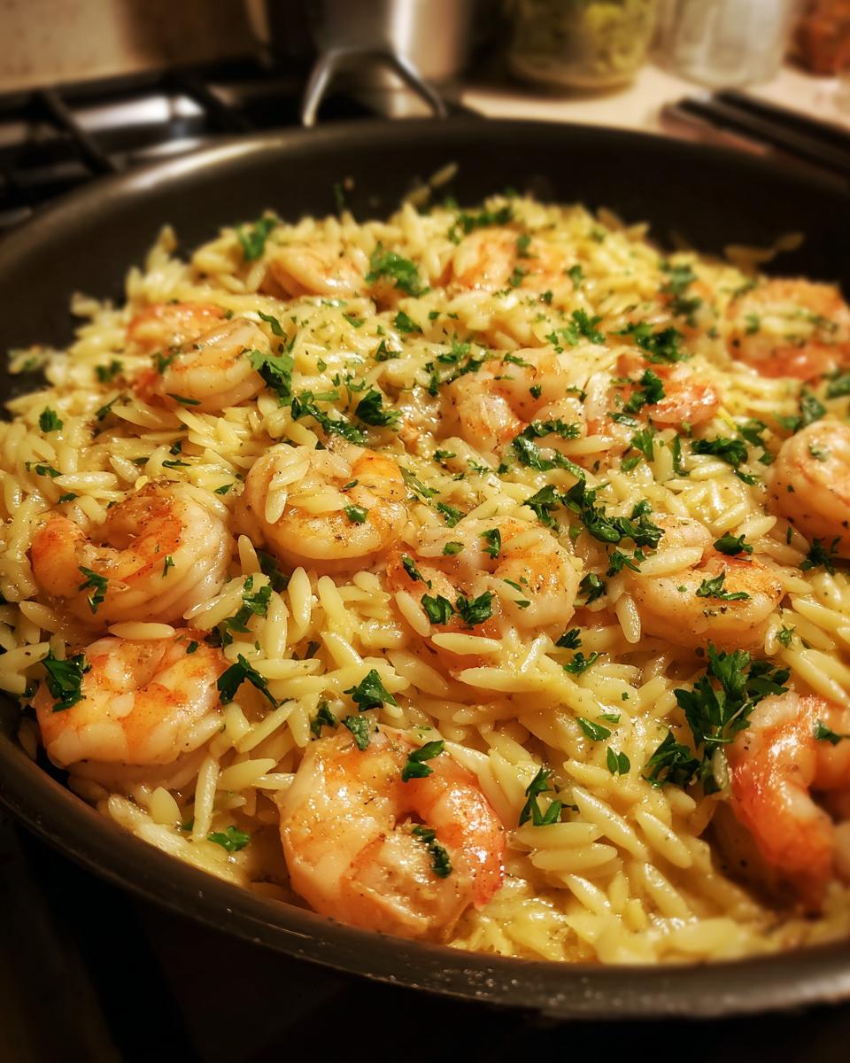 A close-up of shrimp orzo in a lemon garlic sauce, garnished with fresh parsley.