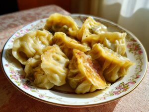 A close-up of a plate filled with golden-brown Traditional Chinese Dumplings, showcasing their pleated wrappers and crispy bottoms.
