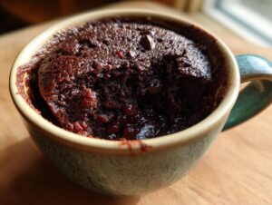 Close-up of a moist and decadent chocolate mug cake with chocolate chips, ready to be enjoyed.