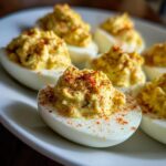 Close-up of creamy deviled eggs topped with paprika, ready to be served.