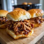 Close-up of delicious pulled pork sliders, generously filled with tender, saucy pulled pork on soft buns.