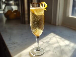A tall, elegant flute glass filled with a bubbly Champagne cocktail, garnished with a lemon twist.