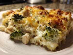 A close-up of a comforting chicken broccoli casserole slice, featuring tender chicken, florets of broccoli, and melted golden cheese.