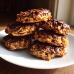 A close-up stack of chocolate-covered no bake cookies made with oats and peanut butter.