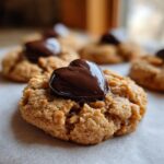 Close-up of a delicious peanut butter blossom cookie topped with a shiny chocolate heart.