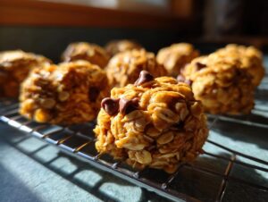 Close-up of homemade peanut butter oatmeal energy bites topped with chocolate chips, arranged on a cooling rack.