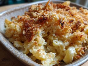 Close-up of creamy baked mac and cheese with a golden-brown, crispy breadcrumb topping.