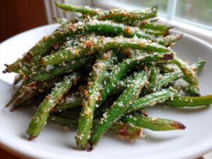 A close-up of roasted green beans sprinkled generously with grated Parmesan cheese.