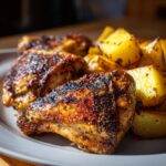 Close-up of perfectly roasted greek lemon chicken pieces served with golden, seasoned potatoes.