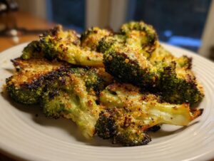 Close-up of perfectly roasted smashed broccoli florets with a crispy, browned, cheesy topping.
