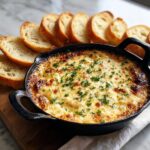 Hot, cheesy baked bread dip topped with parsley, served with toasted baguette slices. Perfect bread dip for parties.