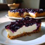 A perfect slice of creamy blueberry cheesecake with a thick graham cracker crust and rich blueberry topping.