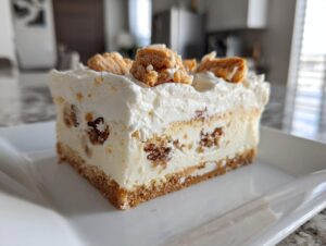 A thick slice of creamy Christmas tree cheesecake with a graham cracker crust and cookie pieces on top.