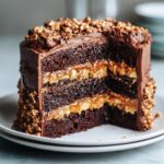 Cross-section of a rich chocolate caramel toffee crunch cake showing three dark layers and gooey caramel filling.