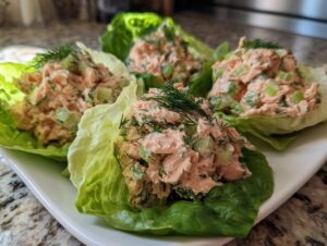 Four servings of creamy salmon salad mixed with celery and dill, served in crisp butter lettuce cups.