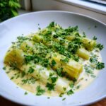 Four tender pieces of braised leeks served in a creamy white sauce and generously topped with fresh chopped parsley.