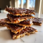 A stack of delicious Caramel Ritz Cracker Christmas Cookies topped with melted chocolate and sea salt.