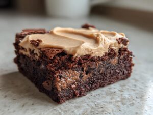 Close-up of a fudgy banana bread brownies square topped with creamy peanut butter frosting.