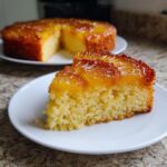 Close-up of a moist slice of pineapple upside down cake with caramelized topping on a white plate.