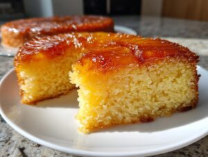 Close-up of a moist slice of pineapple upside down cake showing the fluffy yellow crumb and caramelized topping.