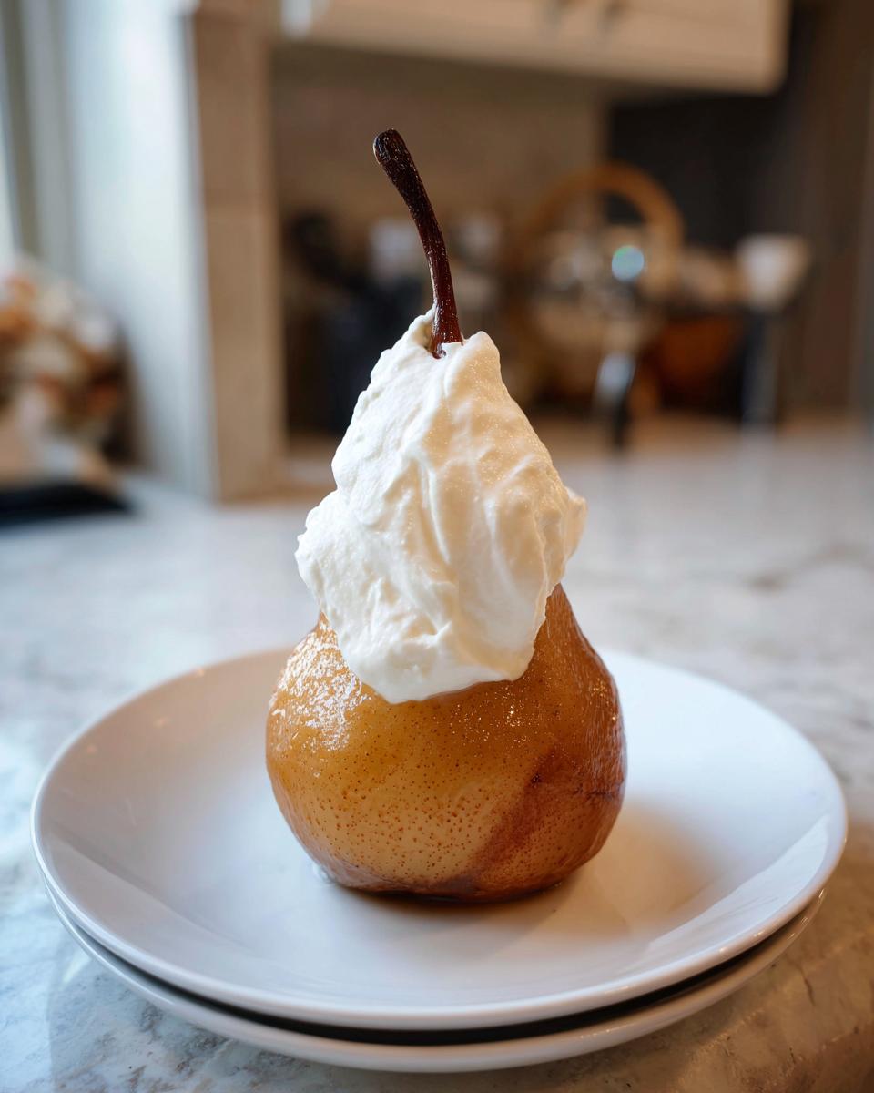 A single, glistening poached pear served on white plates, topped generously with whipped cream.