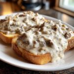 Two slices of golden toast heavily topped with creamy chipped beef on toast gravy.