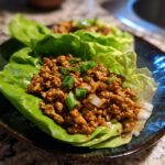 Close-up of savory ground chicken filling served in crisp lettuce cups, making amazing chicken lettuce wraps.